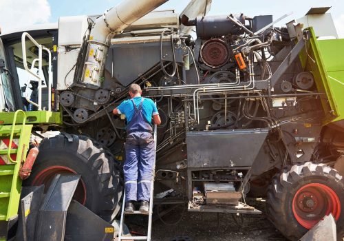 combine-machine-service-mechanic-repairing-motor-outdoors_11zon