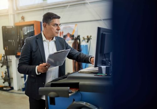 mid-adult-inspector-analyzing-data-while-using-computer-auto-repair-shop_11zon